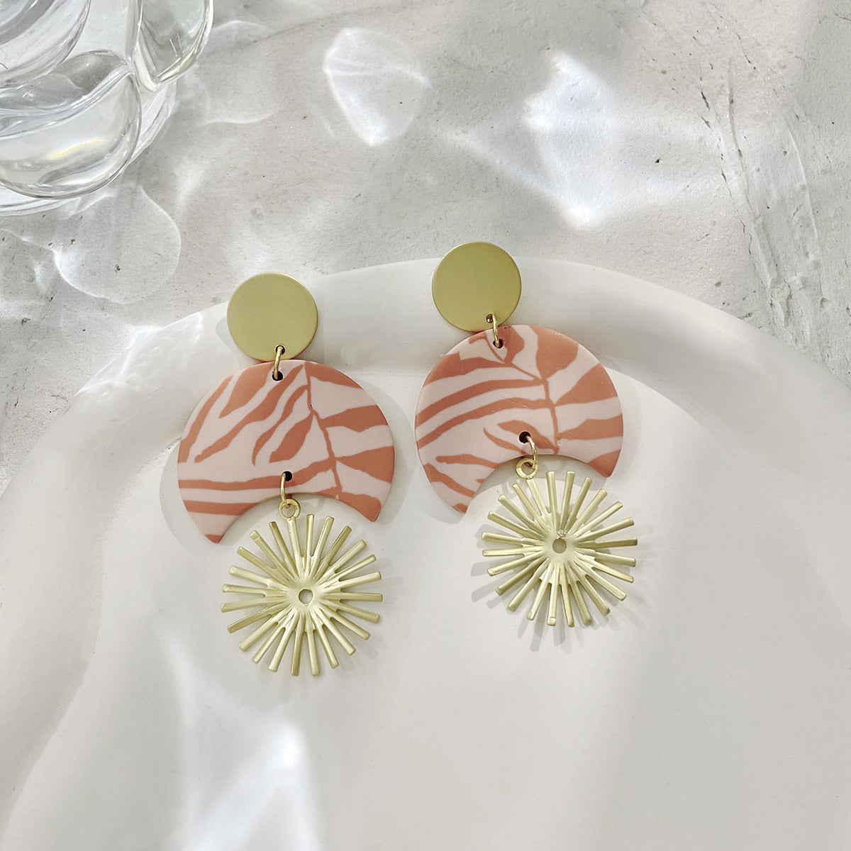 Boucles d'oreilles en argile polymère de Petites Aventures, teintées de blanc et rose poudré, faites à la main avec un motif géométrique