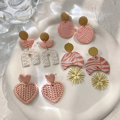 Boucles d'oreilles en argile polymère de Petites Aventures, teintées de blanc et rose poudré, faites à la main avec un motif géométrique