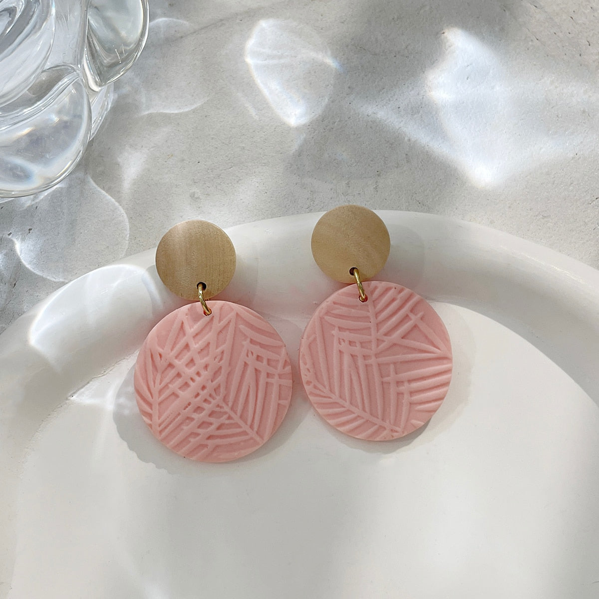 Boucles d'oreilles en argile polymère de Petites Aventures, teintées de blanc et rose poudré, faites à la main avec un motif géométrique