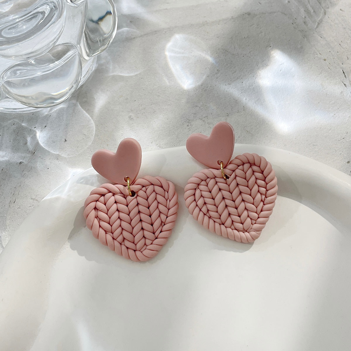 Boucles d'oreilles en argile polymère de Petites Aventures, teintées de blanc et rose poudré, faites à la main avec un motif géométrique rose en forme de coeur