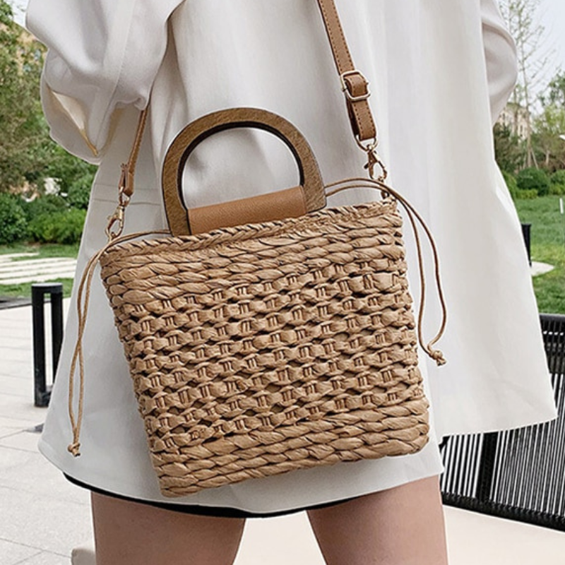 femme qui porte le sac de Couleur Marron Sac à main en paille Sac de plage pour femme Accessoires de plage Sacs à main tendance Sacs d'été Sacs de vacances collection Summer chic de la boutique Petites Aventures