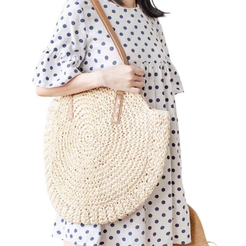 Présentation de la couleur beige porter par une femme du Couleur beige a rayure du sac de plage model sac en paille sac tissé à la main style bohème vacances d'été accessoire de plage fourre-tout bandoulière décontracté raphia collection Summer Chic de la boutique Petites Aventures